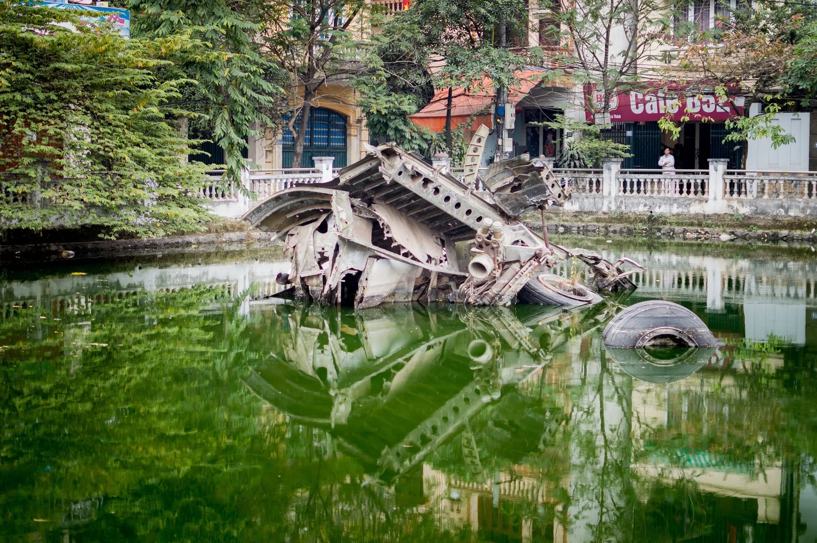 Rusted wreckage of a downed B-52 bomber sits partly submerged in a small lake in Hanoi.