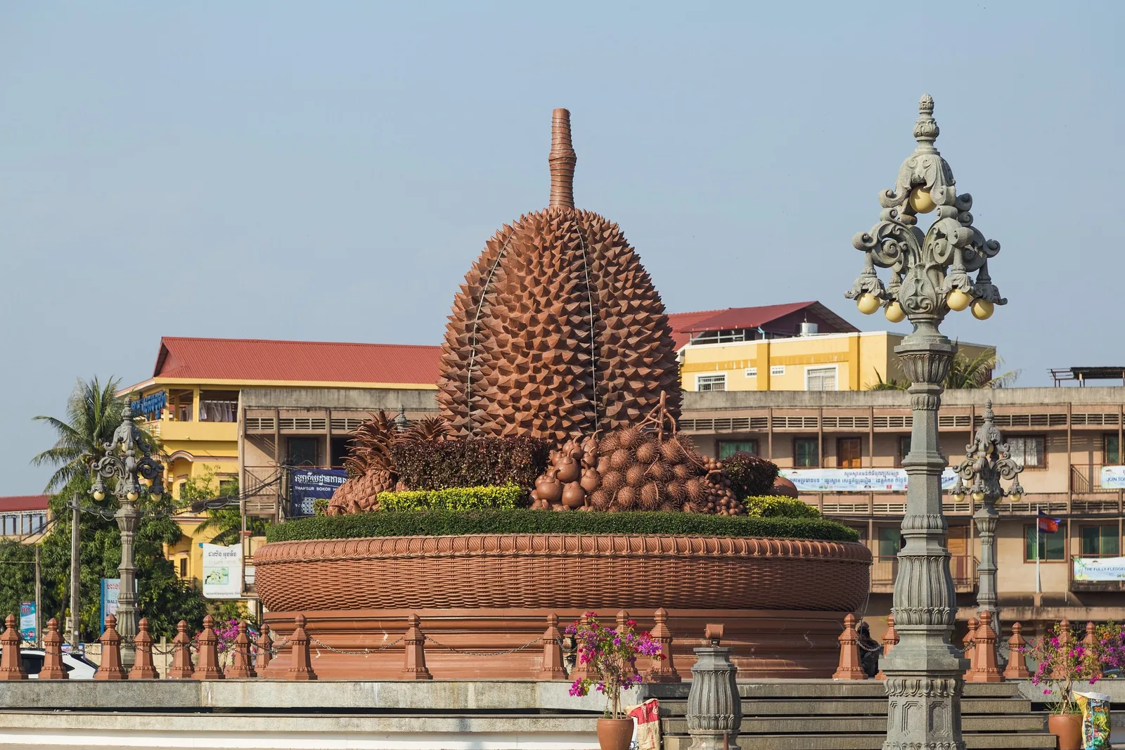 A giant durian fruit statue rises from a large basin at a roundabout in Kampot, Cambodia.
