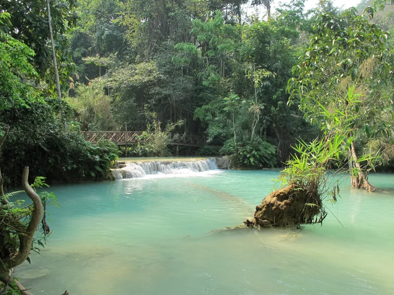 Turquoise pools and a small cascade at Kuang Si Falls near Luang Prabang, surrounded by lush jungle.