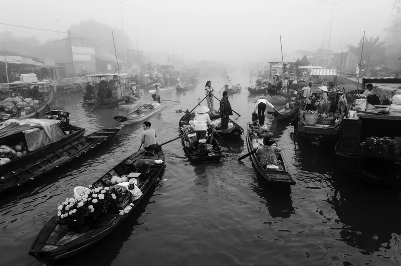 Wooden boats loaded with produce and flowers crowd the misty water at Nga Nam floating market in Soc Trang, Mekong Delta. Wooden boats loaded with produce and flowers crowd the misty water at Nga Nam floating market in Soc Trang, Mekong Delta.