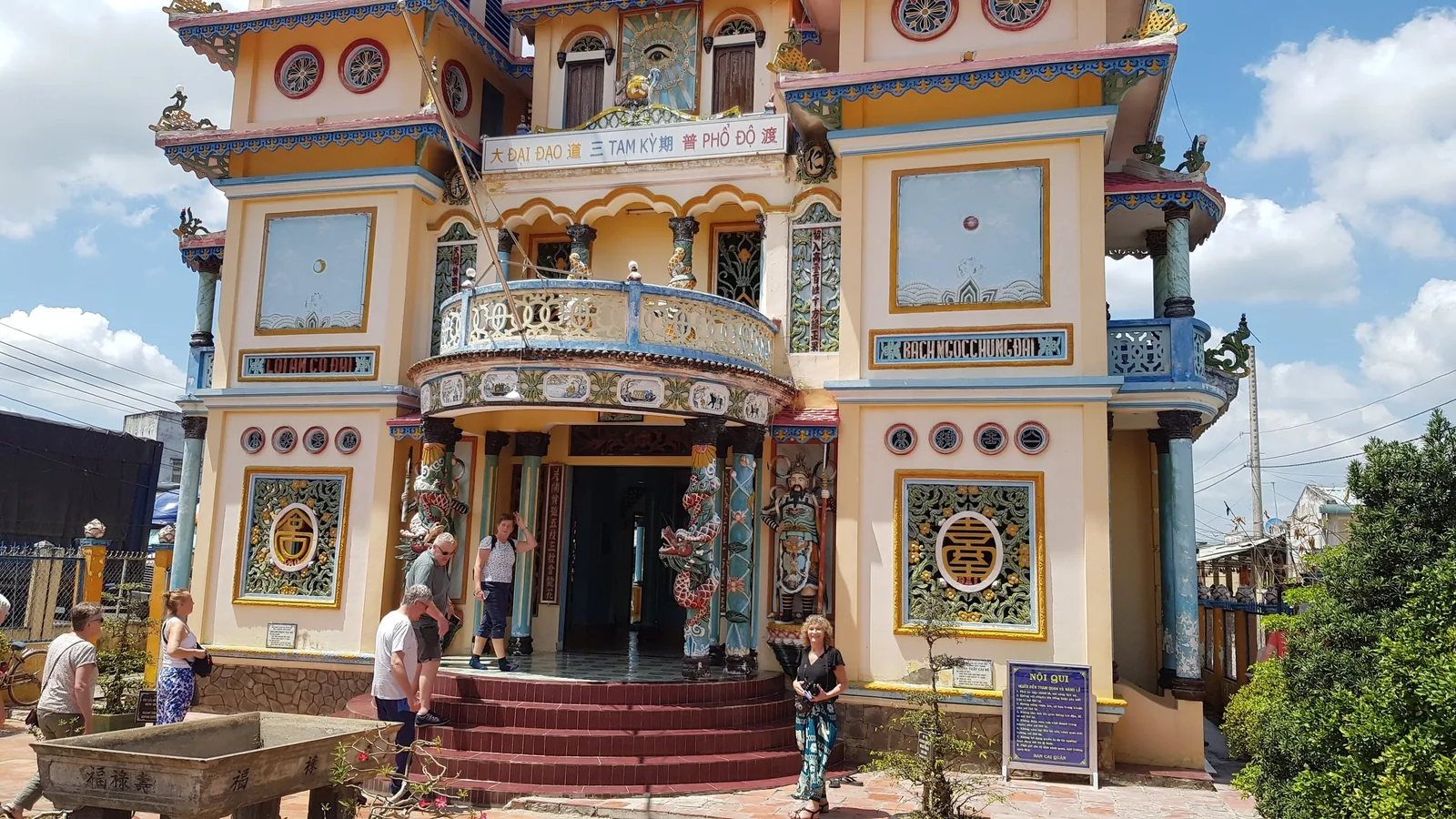 Visitors gather outside the ornate, colorfully decorated Cao Dai temple facade in the Mekong Delta. Visitors gather outside the ornate, colorfully decorated Cao Dai temple facade in the Mekong Delta.